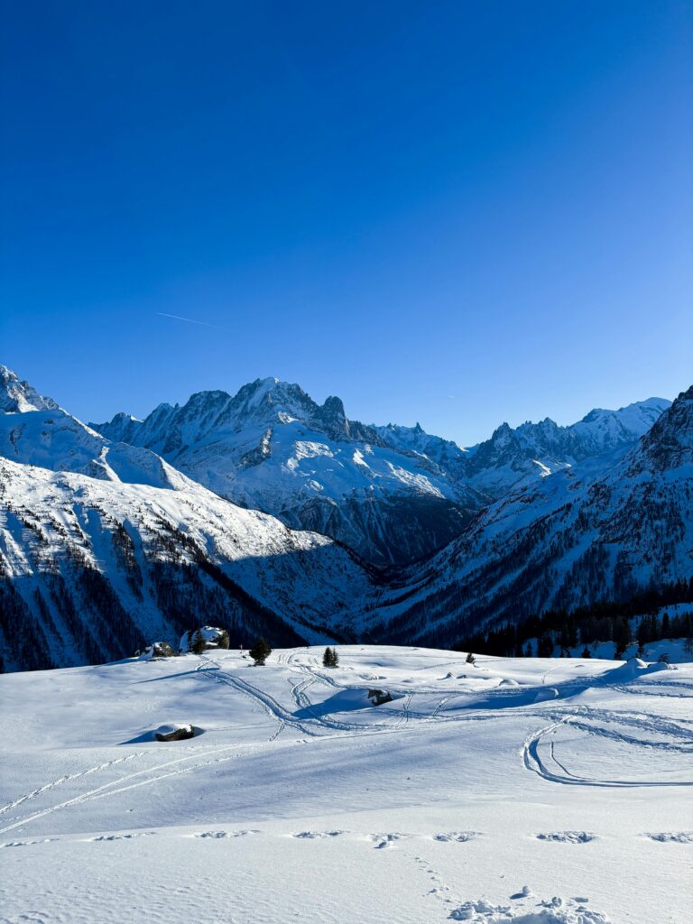 Breathtaking view of the snow-covered French Alps during winter with clear blue skies.
