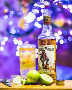 Close-up of rum cocktail with lime in a vibrant nightlife setting, perfect for party vibes.
